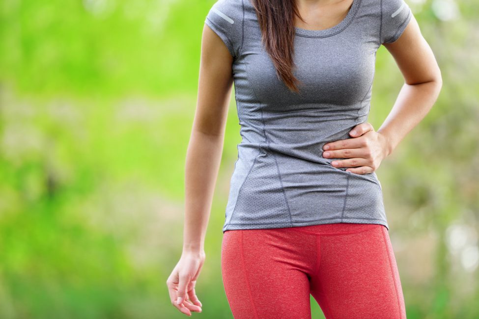 young woman holding stomach in pain