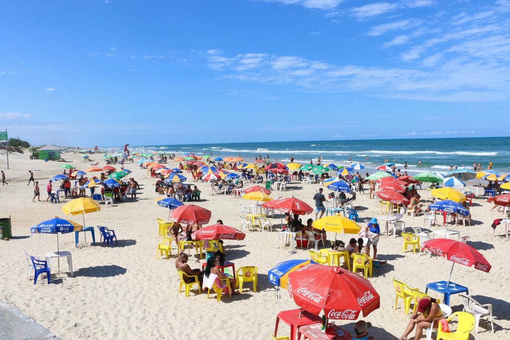 crowded public beach with umbrellas