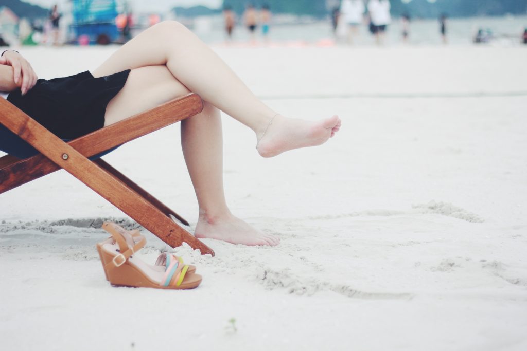 woman's legs crossed on a beach