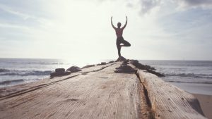 woman in yoga pose at end of boardwalk