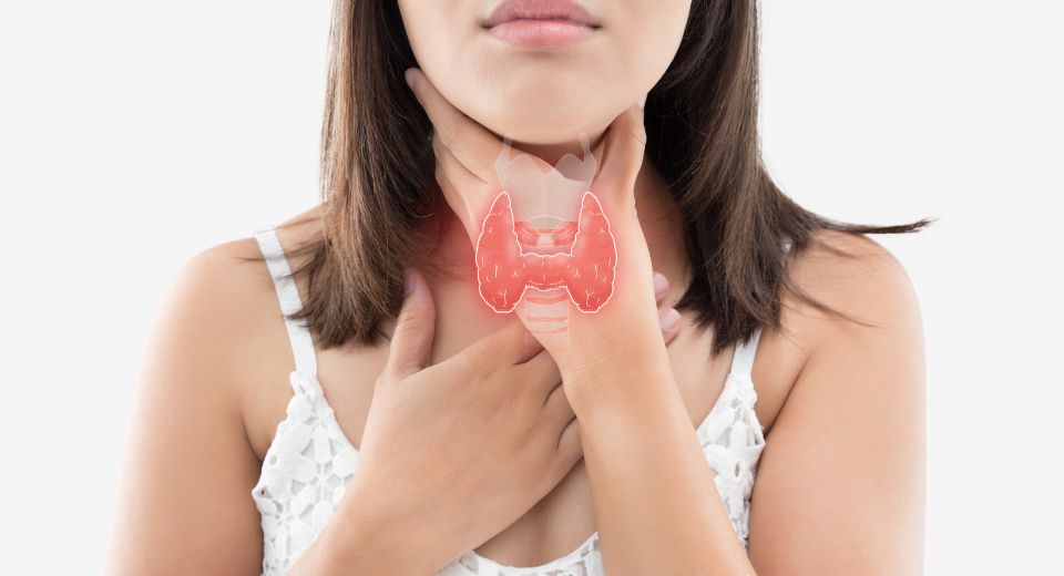 Girl holding the front of her neck where the thyroid is located