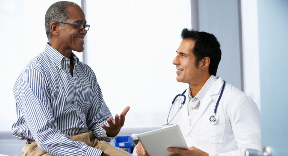Male doctor speaking with a male patient