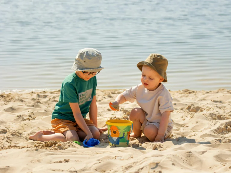 Small children playing with toys in the sand on the beach