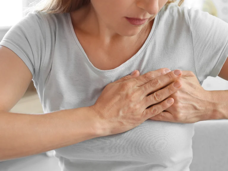 A women holding her breast like it hurts